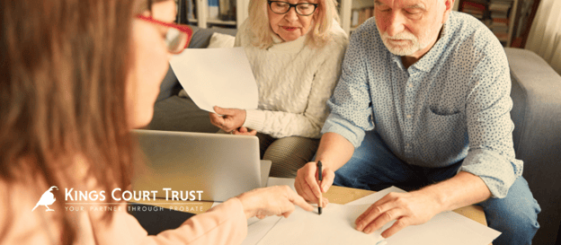 An older couple looking through paperwork with an adviser