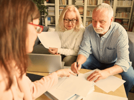 Elderly couple signing paperwork