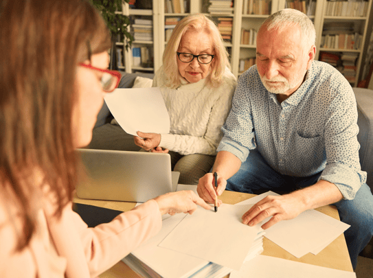 Elderly couple signing paperwork