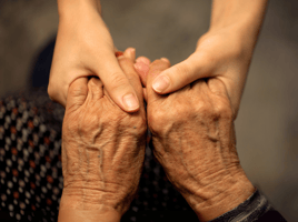 Older person holding hands with younger person