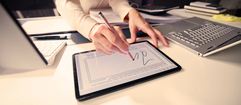 Someone signing a document on their tablet using a stylus