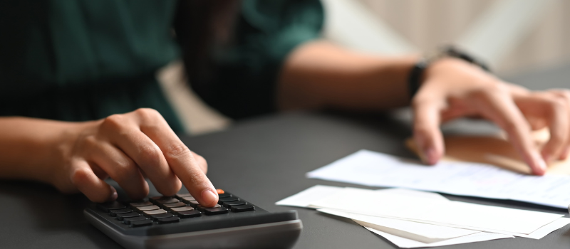 Person using a calculator and reviewing receipts