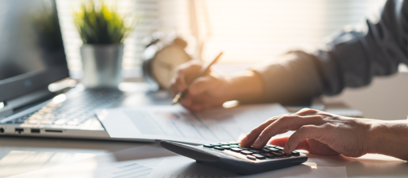 Person doing paperwork and using a calculator