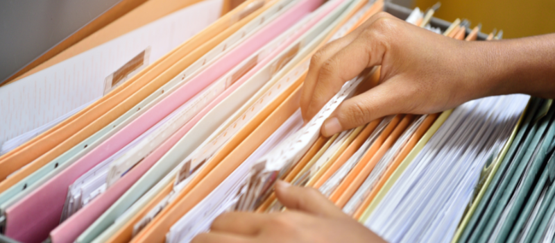 A person searching through files for a Will and/or other important documents